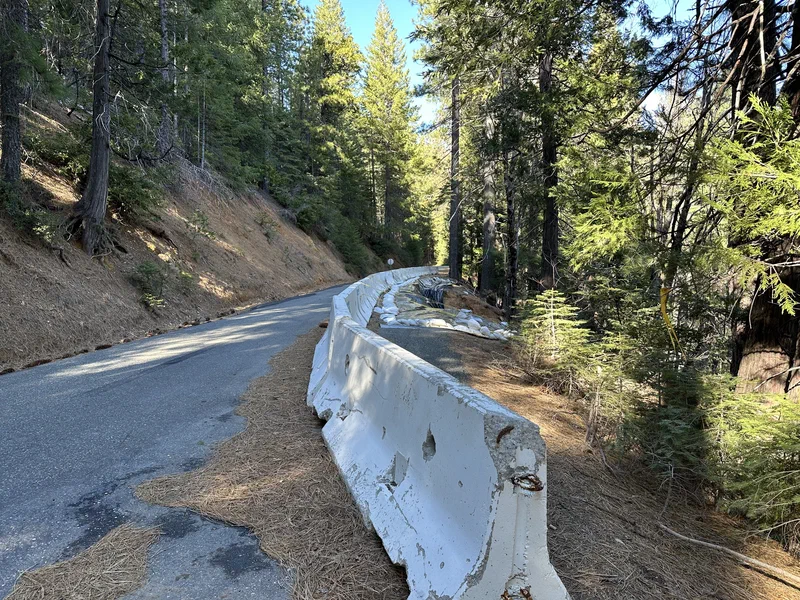 The Skyway approaching the failure, with a line of concrete K-rail barriers running along the right-hand edge of the road and sandbags visible further ahead